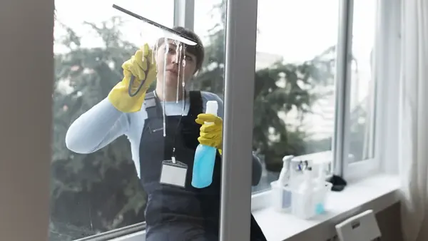Cleaning an interior office window with a squeegee