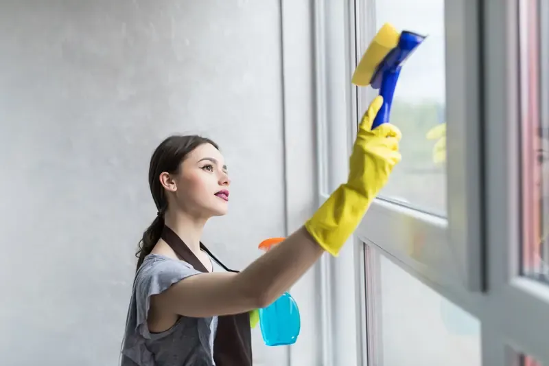 Cleaning a residential window with a squeegee and microfiber cloth